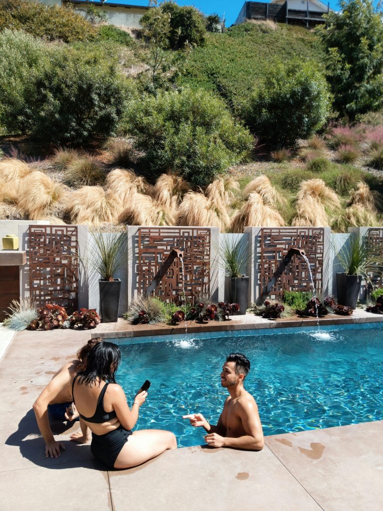 pexels photo 2975682 2975682 Friends enjoying leisure time by a scenic poolside surrounded by lush greenery in summer.