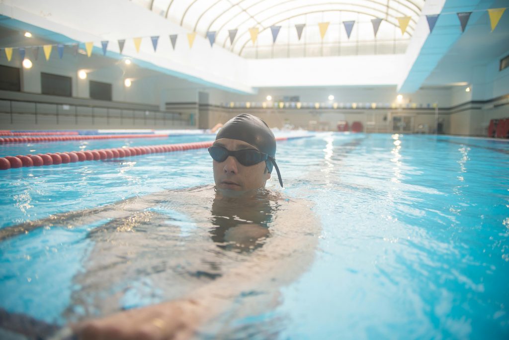 pexels photo 6539739 6539739 Man swimming in an indoor pool, wearing goggles and cap, showcasing healthy lifestyle and focus.